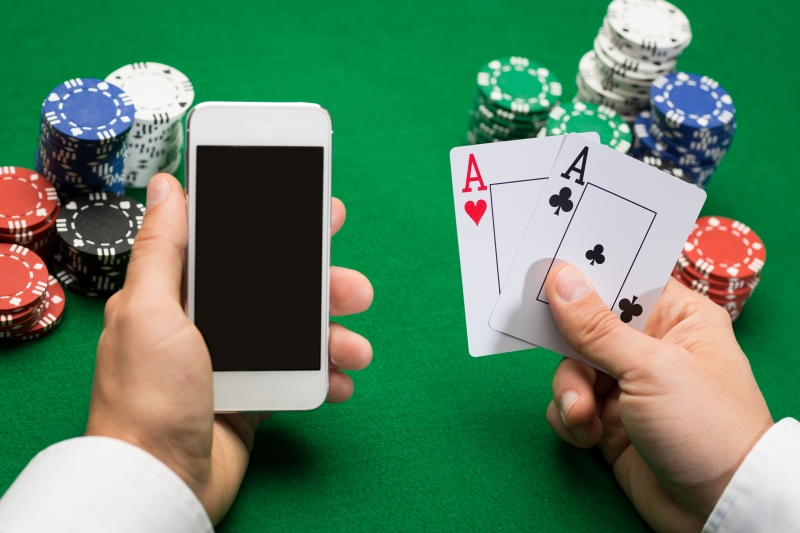 10580367-casino-player-with-cards-smartphone-and-chips